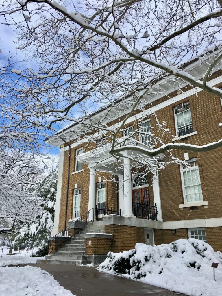 Shows the side entrance of Blaney hall, snow on the ground and on nearby tree limbs