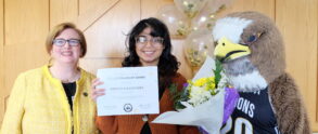 Scholarship winner stands holding their certificate, flowers, and balloons alongside President Elizabeth Meade and Franki the Falcon
